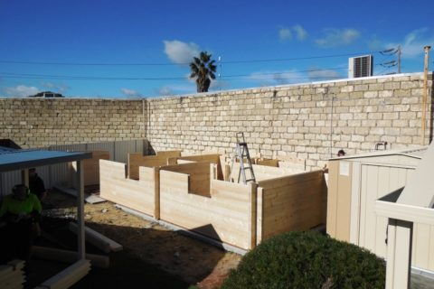 Construction of a new wooden structure on a sunny day with clear skies and building materials scattered around received Shire Council approval. Phoenix Patios, Cottages and Granny Flats in Perth